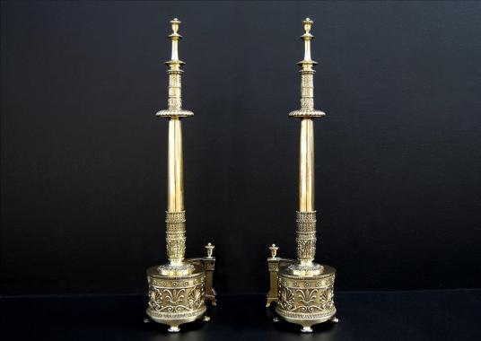 A impressive pair of English Regency brass firedogs with Aethenian leaves