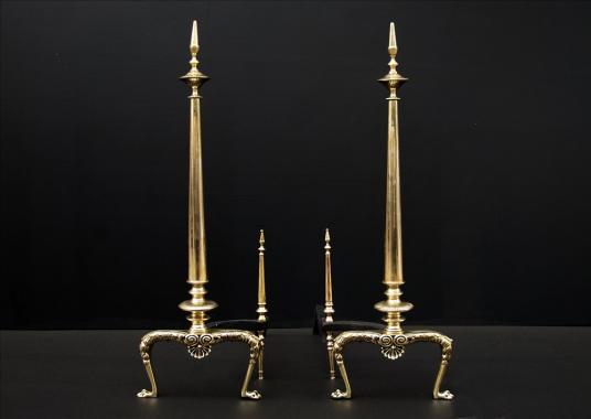 A pair of tapering brass firedogs