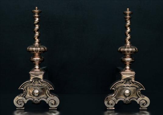A pair of bronze firedogs with barley twist tops