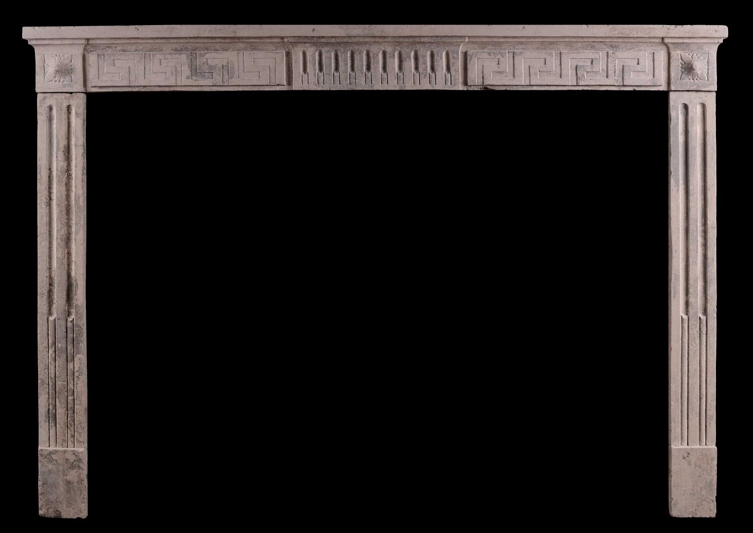 A rustic 18th century Louis XVI fireplace with Greek key motif