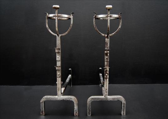 A pair of steel firedogs with mulling tops