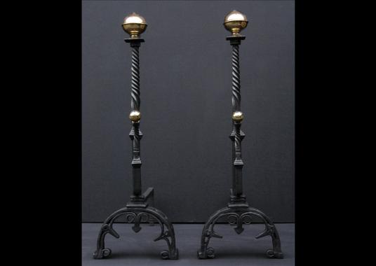 A pair of wrought iron firedogs with barley twist shafts