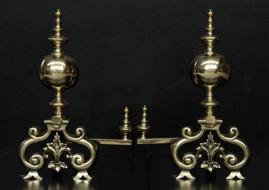 A pair of large brass firedogs