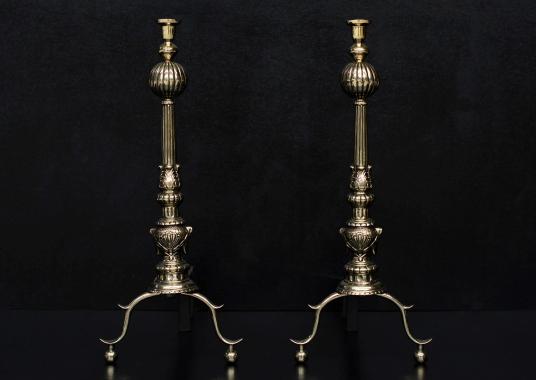 A pair of English brass firedogs with gadrooned finials