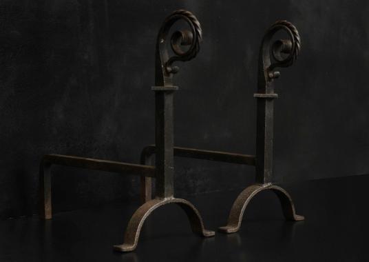 A pair of scrolled wrought iron firedogs