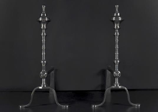 A pair of elegant polished steel firedogs