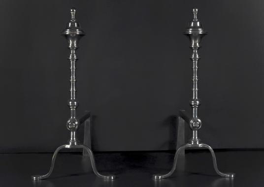 A pair of elegant polished steel firedogs