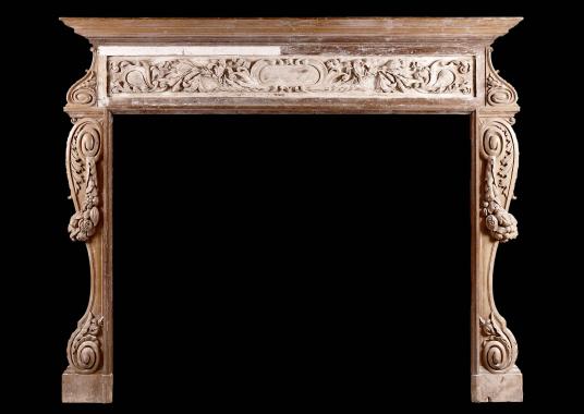 A large and rustic antique wood fireplace with carved fruit and foliage