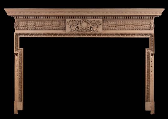 A well carved English pine fireplace with barrell frieze and oak leaves
