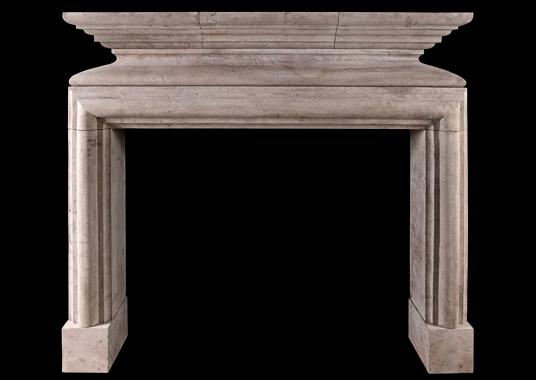 A rustic French Louis XIII style limestone fireplace
