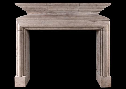 A rustic French Louis XIII style limestone fireplace