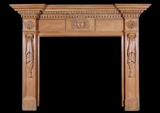 A 19th century English oak fireplace with carved mask to centre