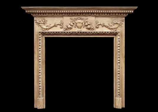 An English Georgian style pine fireplace with gesso enrichments