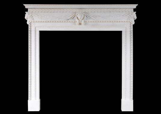 A white marble fireplace with carved lion's mask