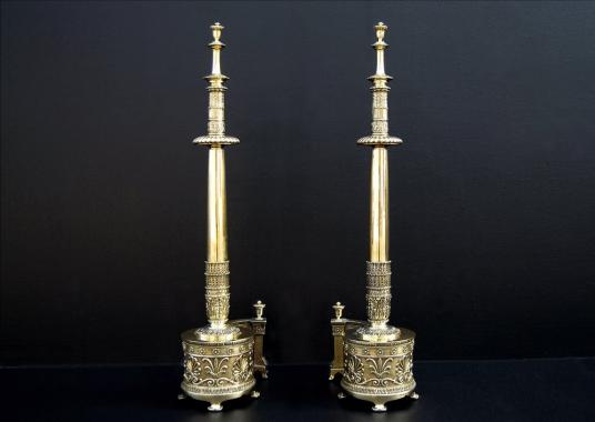 A impressive pair of English Regency brass firedogs with Aethenian leaves