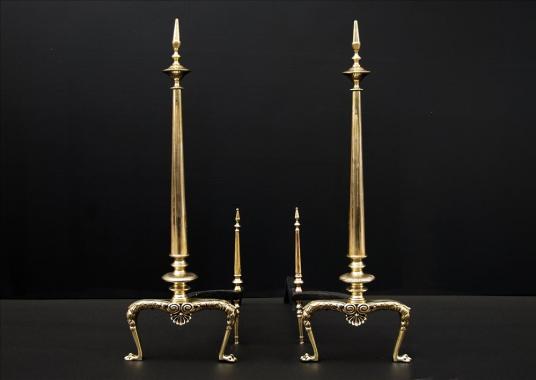 A pair of tapering brass firedogs