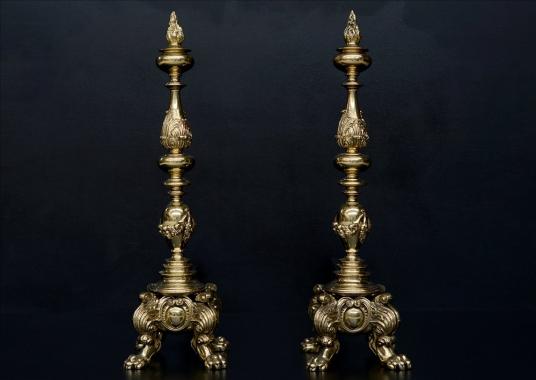 A large pair of ornate brass firedogs