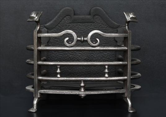 A polished wrought iron firebasket from the Arts and Crafts movement