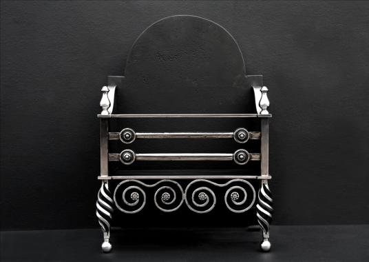 An English Arts and Crafts polished iron firegrate