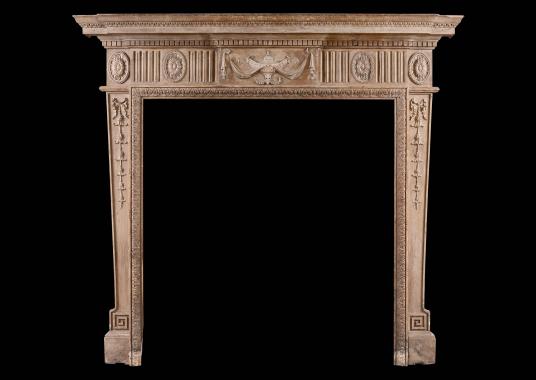 A Neo-Classical pine fireplace with carved urn