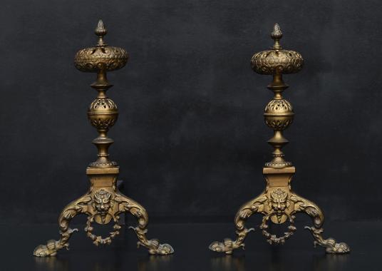 A pair of ornate brass firedogs