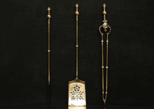 A set of brass firetools with decorative finials