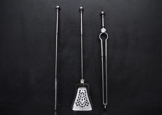 A set of polished steel firetools