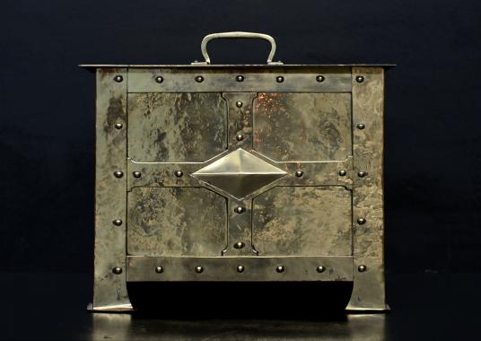 A brass coalbucket in the neo-Gothic manner