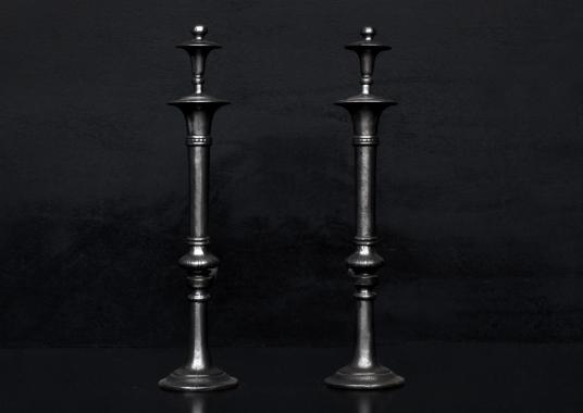 A pair of polished cast iron firedogs