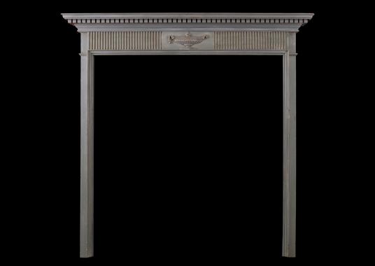 A small Regency wood fireplace with carved urn