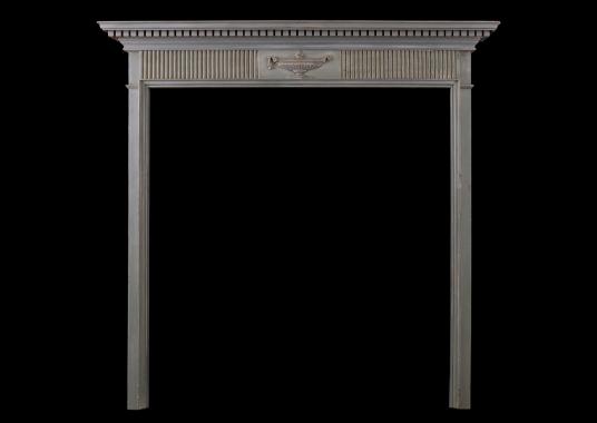 A small Regency wood fireplace with carved urn