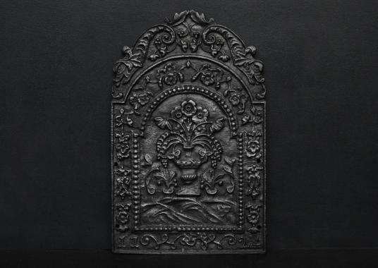 A decorative cast iron fireback