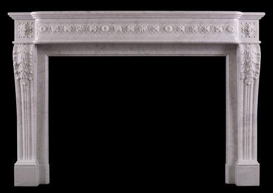 A carved marble fireplace in the Louis XVI manner
