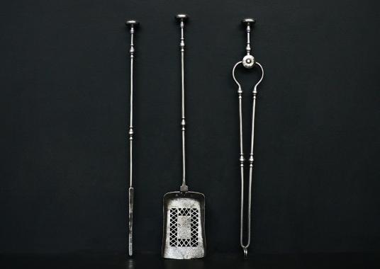 A set of polished steel firetools