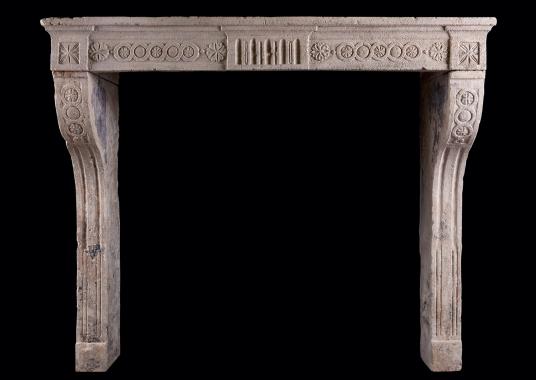 A rustic Louis XVI stone fireplace