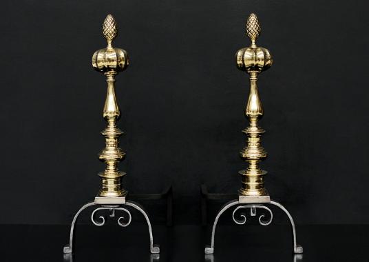 A pair of brass and steel firedogs