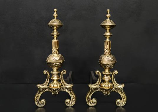 An ornate pair of brass firedogs