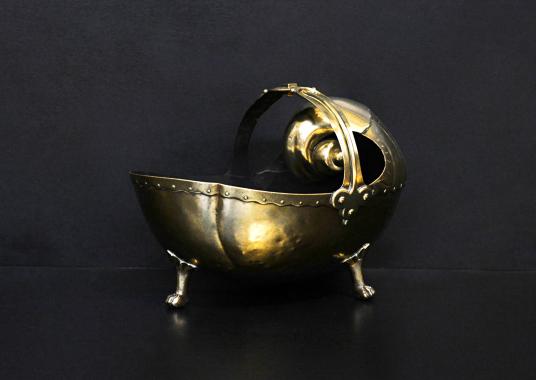 A decorative brass coal bucket