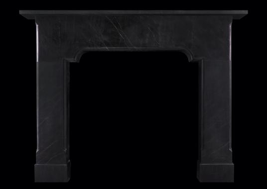 An imposing architectural black marble fireplace