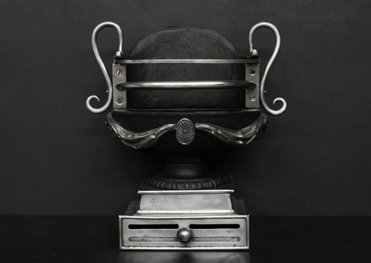 A polished cast iron urn firegrate in the Regency style