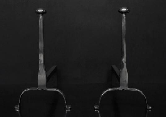 A pair of elegant firedogs in polished steel