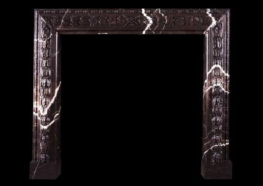 A carved bolection fireplace Brown Marquina marble