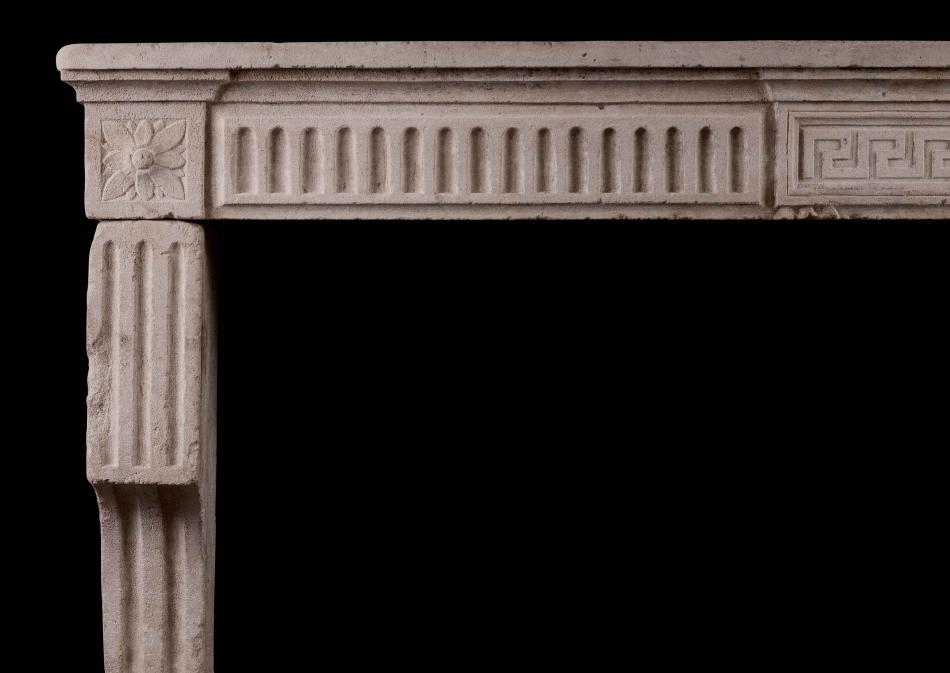 A Period 18th Century Louis XVI stone fireplace with Carved Greek Key and Fluting