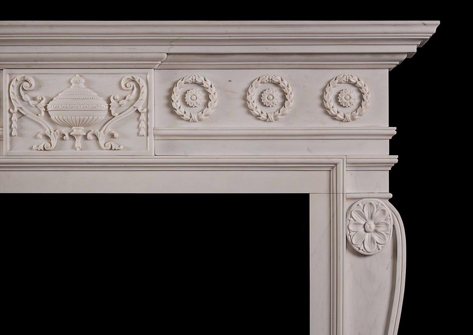 A late Georgian style carved chimneypiece in white marble