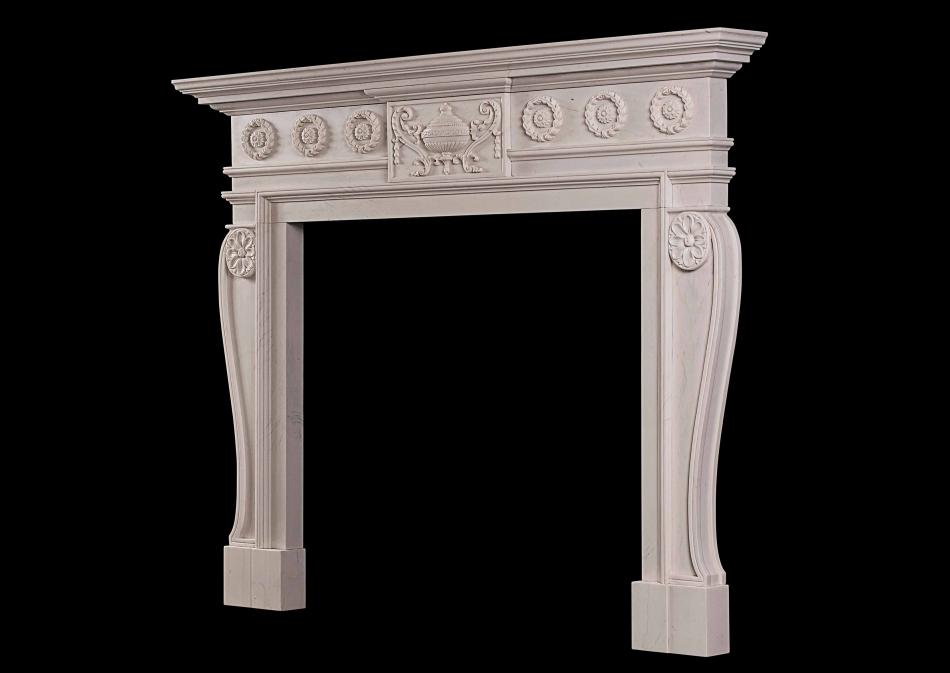 A late Georgian style carved chimneypiece in white marble