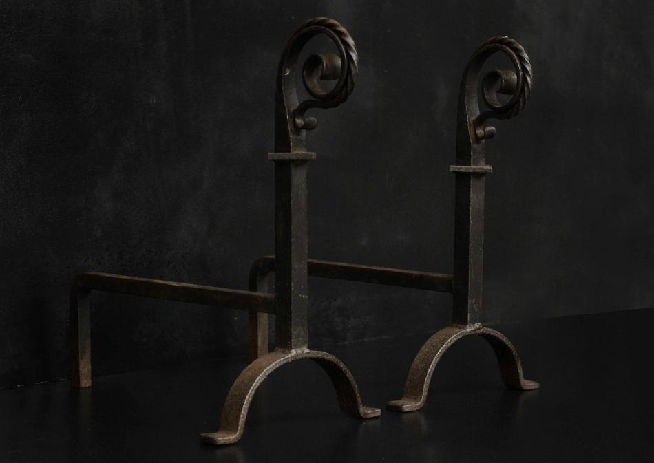 A pair of scrolled wrought iron firedogs