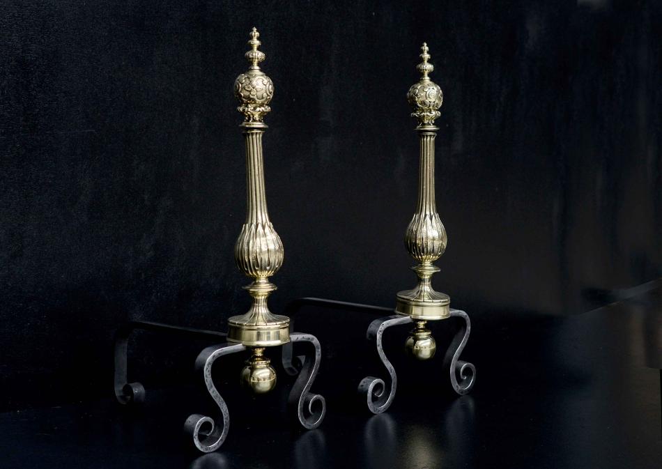 A pair of polished brass and wrought iron firedogs