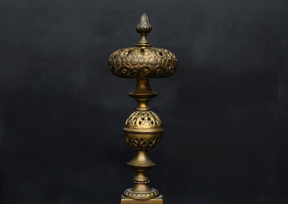 A pair of ornate brass firedogs