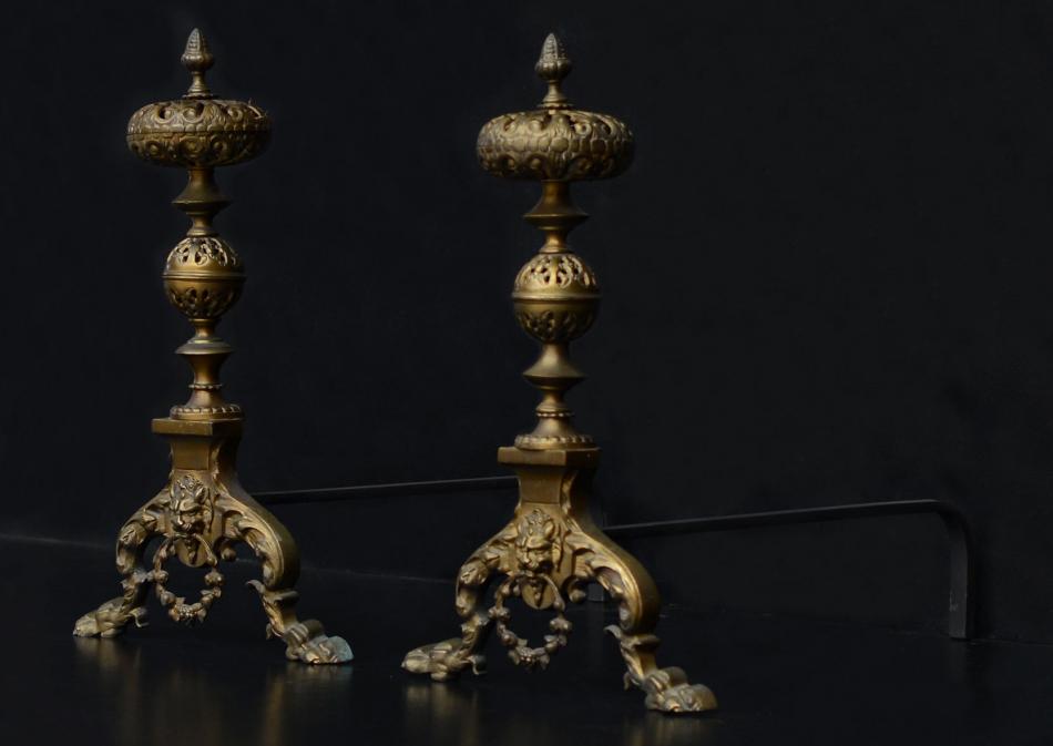 A pair of ornate brass firedogs