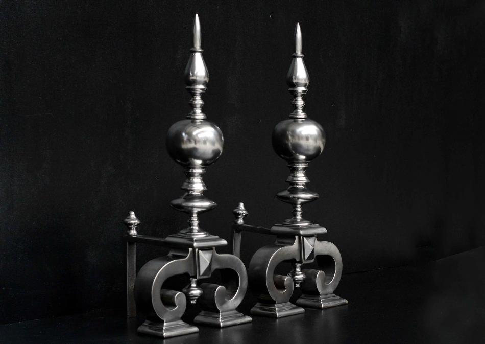 A large pair of antique polished steel firedogs